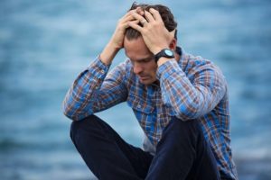 Man holding head on beach featured image